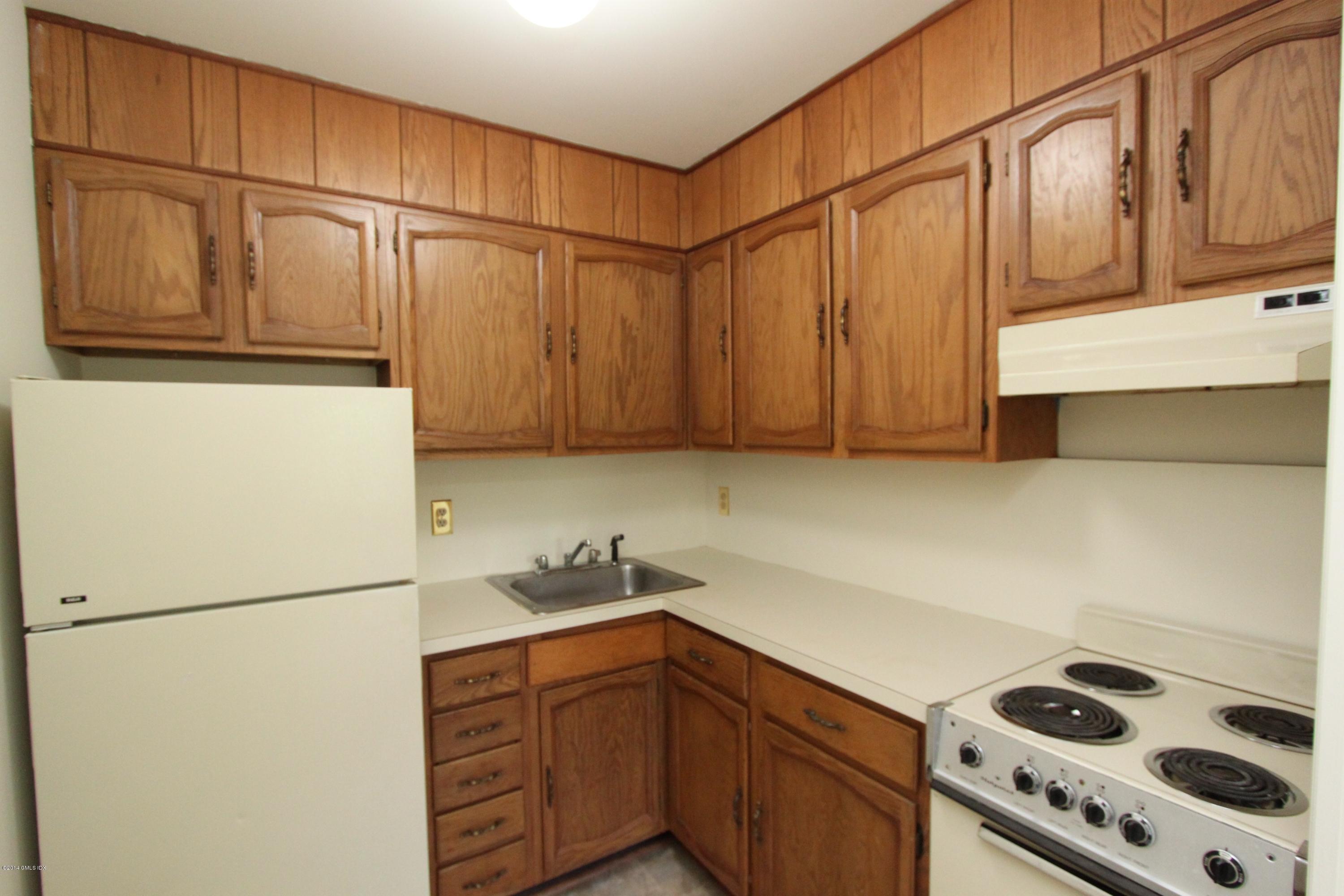 9 Weaver Street, Unit 9 Greenwich, CT 06831 - Photo 4 of 6 a kitchen with stainless steel appliances wooden cabinets and a refrigerator