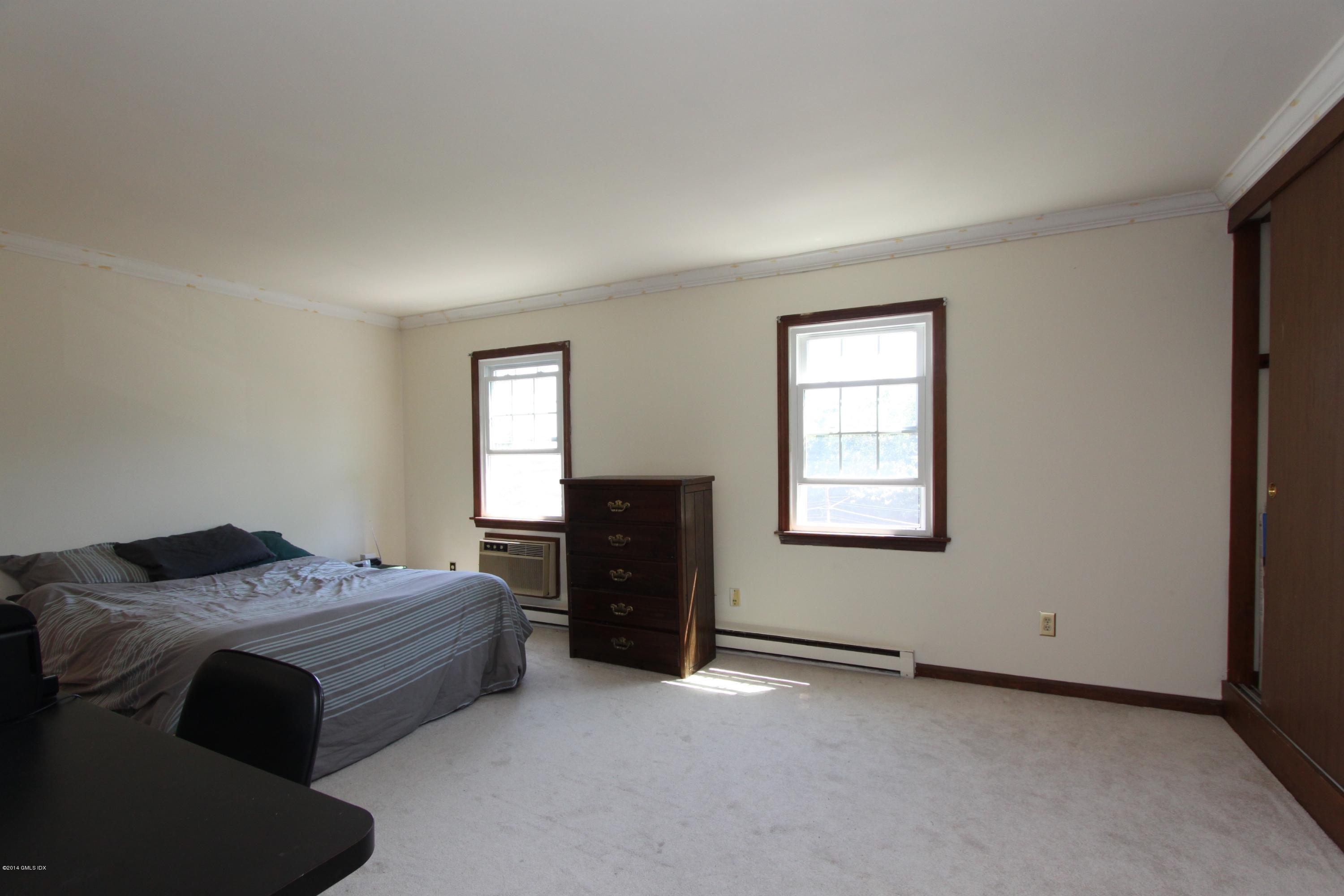 9 Weaver Street, Unit 9 Greenwich, CT 06831 - Photo 5 of 6 a bed room with a bed and a window
