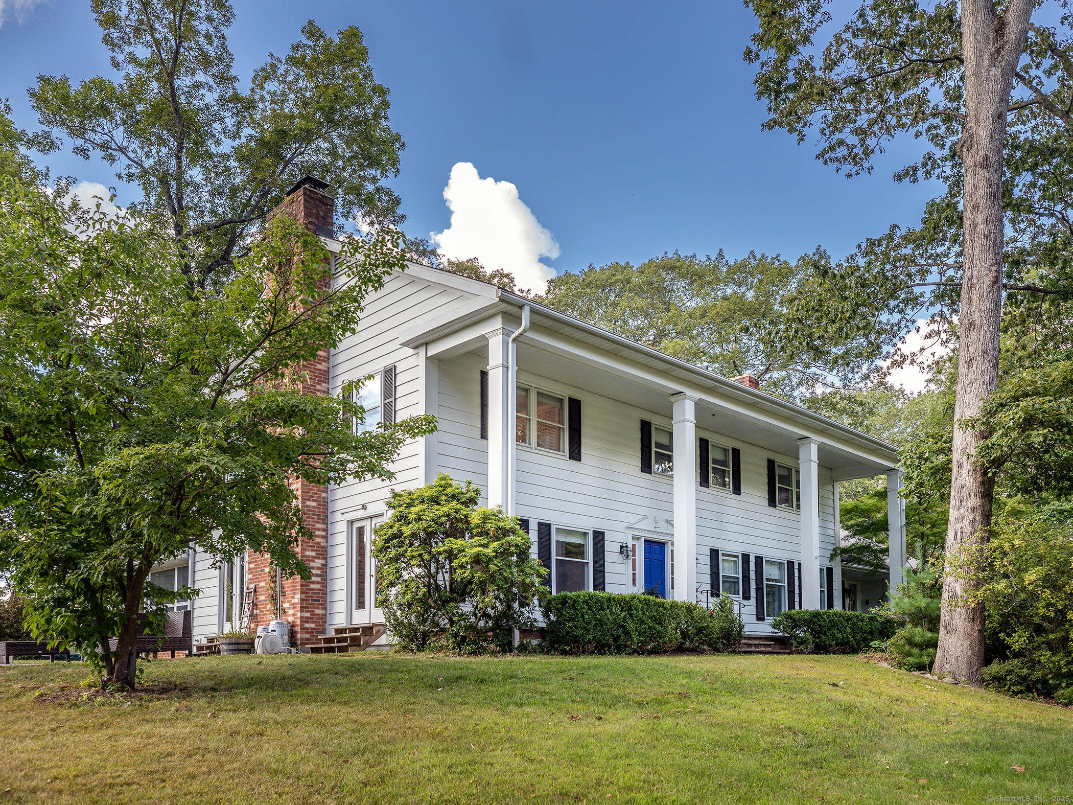 a front view of a house with a garden and trees