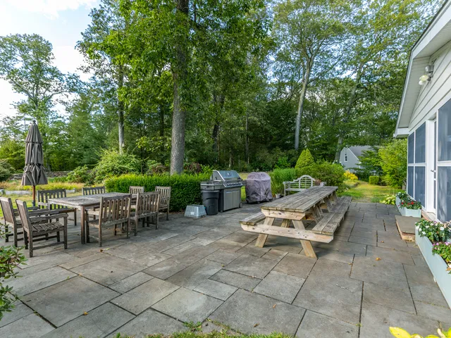 a view of a chairs and table in backyard of the house