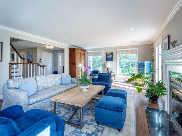 a living room with furniture potted plant and a large window