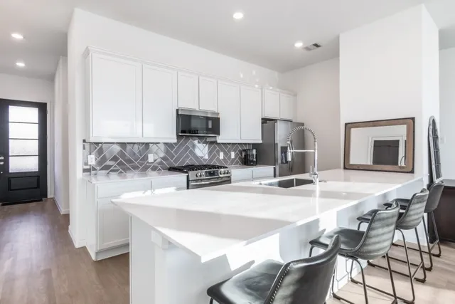 a kitchen with stainless steel appliances a sink stove and cabinets
