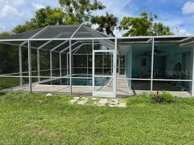 a view of a backyard with floor to ceiling window next to a yard