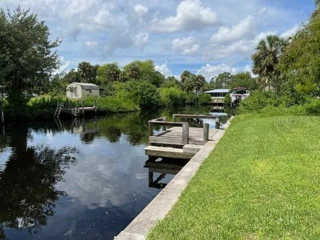 a view of a lake with a bench and trees around
