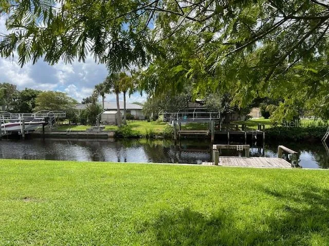 a view of lake with table and chairs and wooden fence