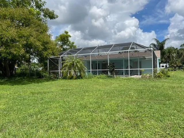 a view of a house with backyard and a garden
