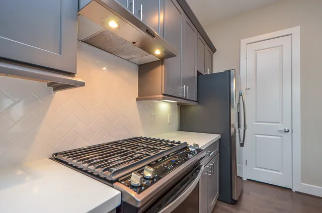 a stove top oven sitting inside of a kitchen