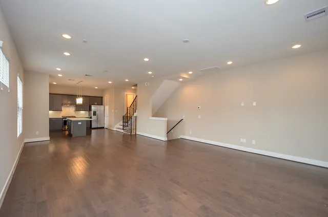a view of an empty room with kitchen