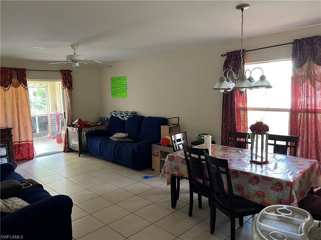 4618 19th Court Southwest Naples, FL 34116 - Photo 2 of 16 a living room with furniture a window and a chandelier
