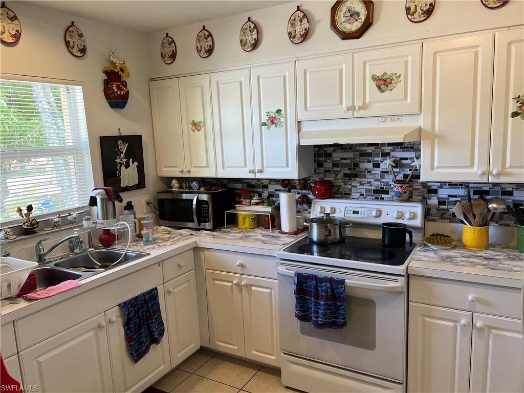 4618 19th Court Southwest Naples, FL 34116 - Photo 3 of 16 a kitchen with a stove and a white cabinets