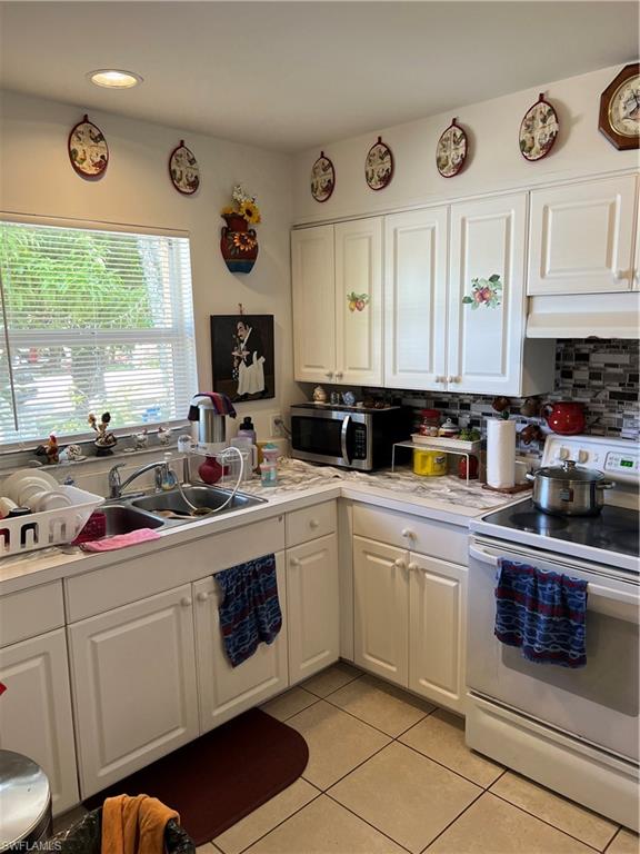 4618 19th Court Southwest Naples, FL 34116 - Photo 6 of 16 a kitchen with stainless steel appliances a stove a sink and a refrigerator