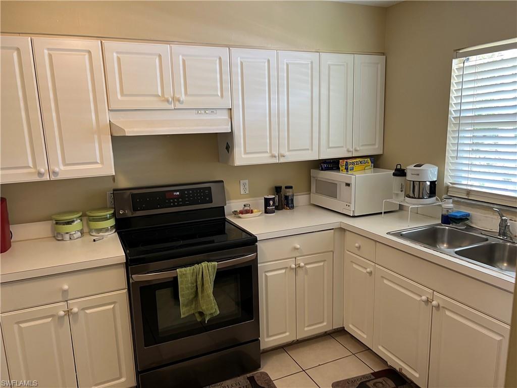 4618 19th Court Southwest Naples, FL 34116 - Photo 10 of 16 a kitchen with granite countertop white cabinets and white appliances