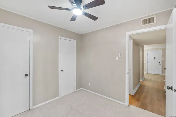a view of a hallway with a chandelier fan