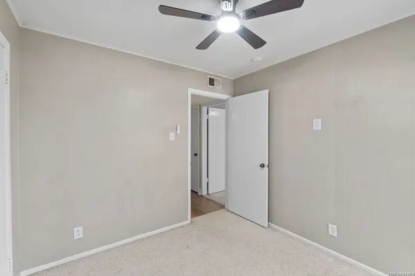 an empty room with closet and a chandelier fan