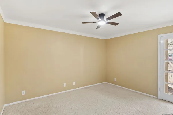 an empty room with a ceiling fan and a window