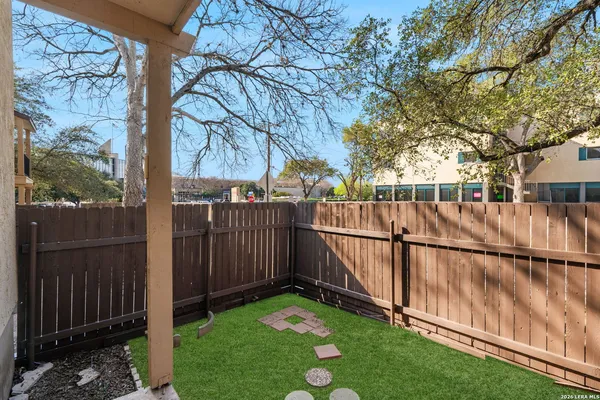 a view of backyard with wooden fence and large trees