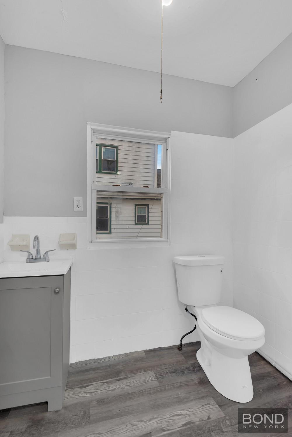 119-73 Merrill Street Queens, NY 11434 - Photo 5 of 12 a white toilet sitting next to a bathroom sink