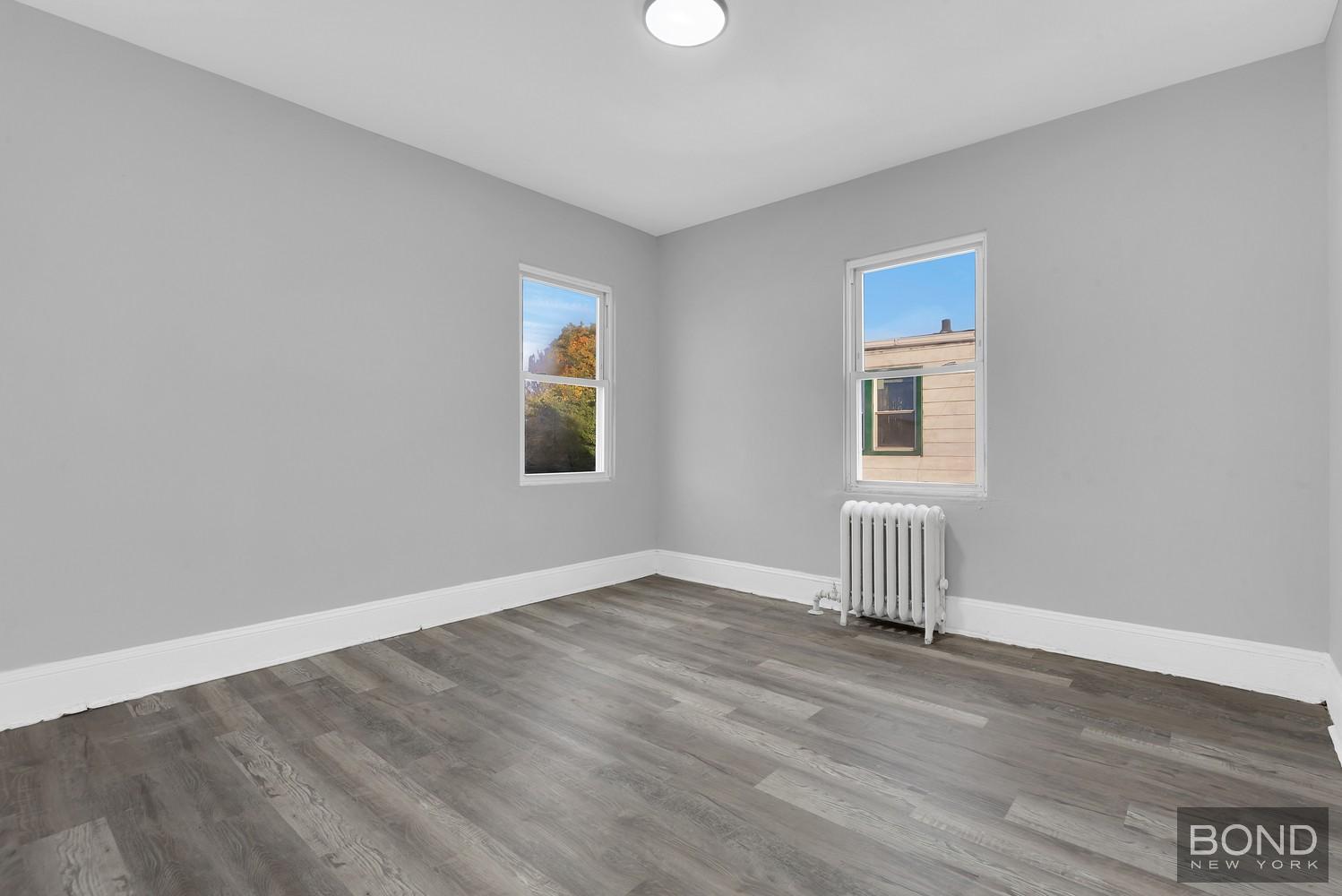 119-73 Merrill Street Queens, NY 11434 - Photo 7 of 12 an empty room with a door and a window