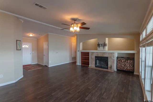 a view of a livingroom with a fireplace a chandelier and wooden floor