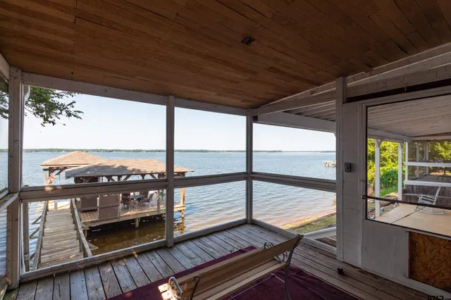 a view of a balcony with floor to ceiling windows with wooden floor