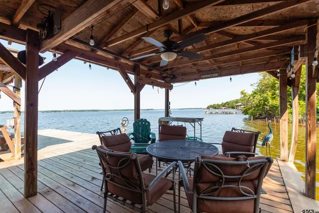 a patio table and chairs with potted plants