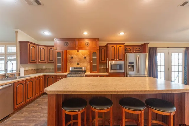 a kitchen with a table chairs sink and wooden floor