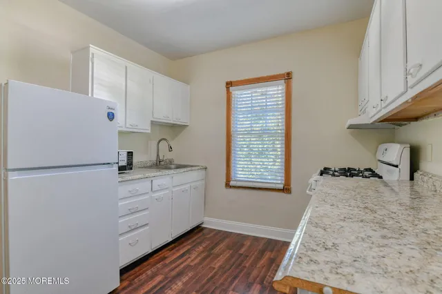 a kitchen with a refrigerator stove and white cabinets