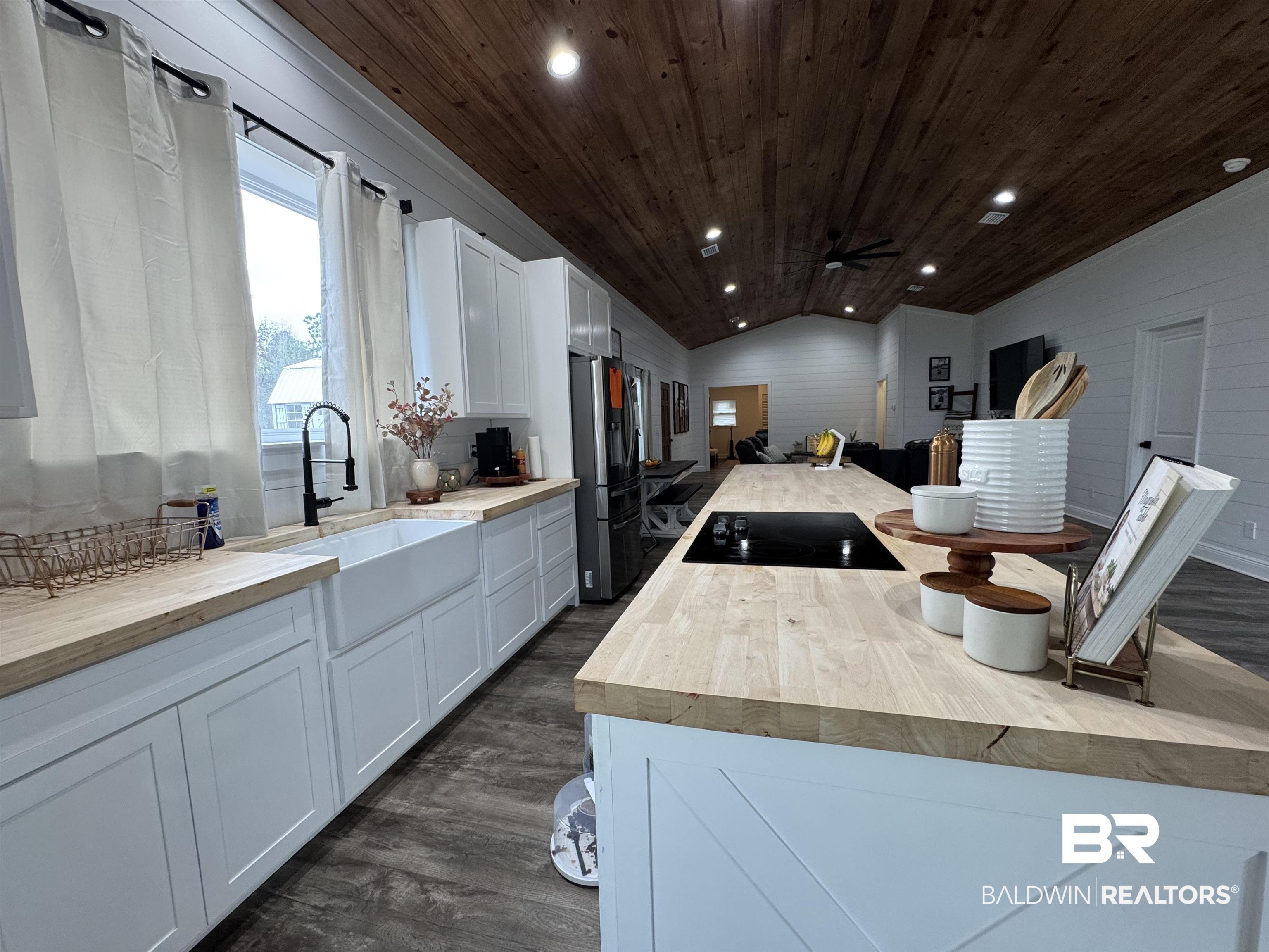 370 Dianne Road Frisco City, AL 36445 - Photo 8 of 41 Kitchen featuring white cabinets, black electric stovetop, vaulted ceiling, and wood counters