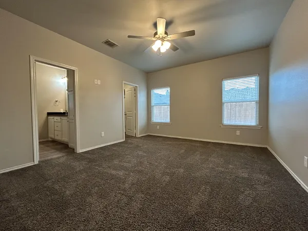 an empty room with fan and windows