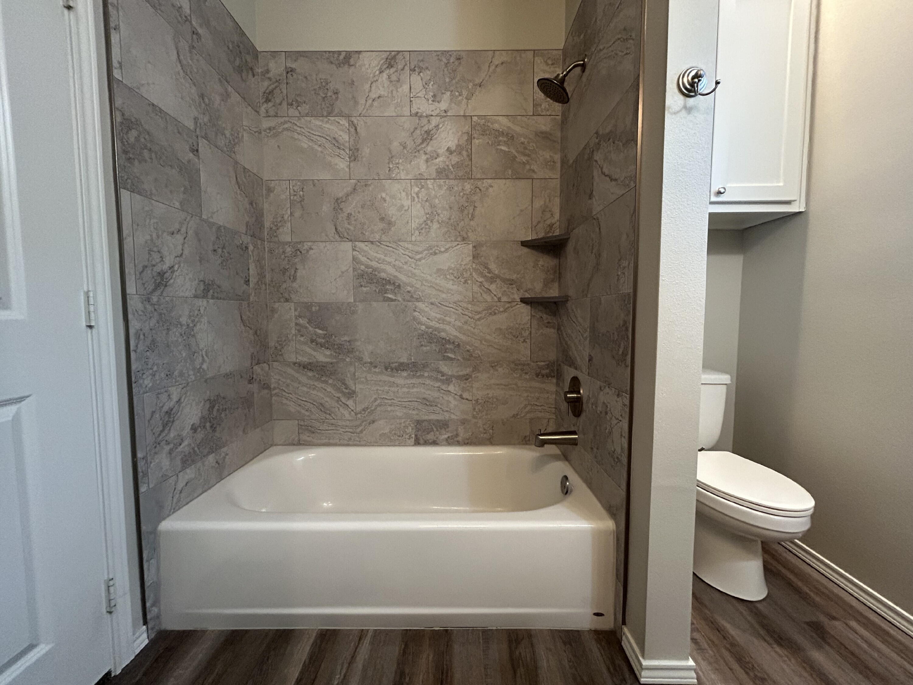 5843 Itasca Street Lubbock, TX 79416 - Photo 7 of 10 a bathroom with a bathtub and a toilet