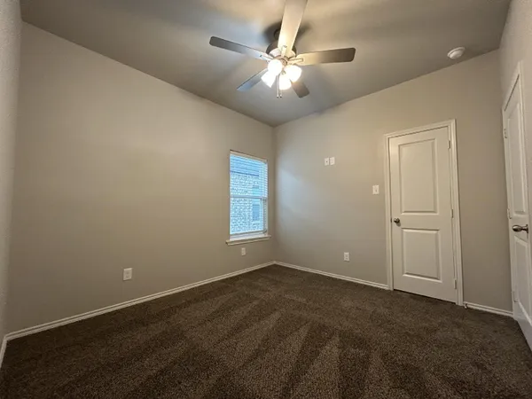an empty room with fan and windows