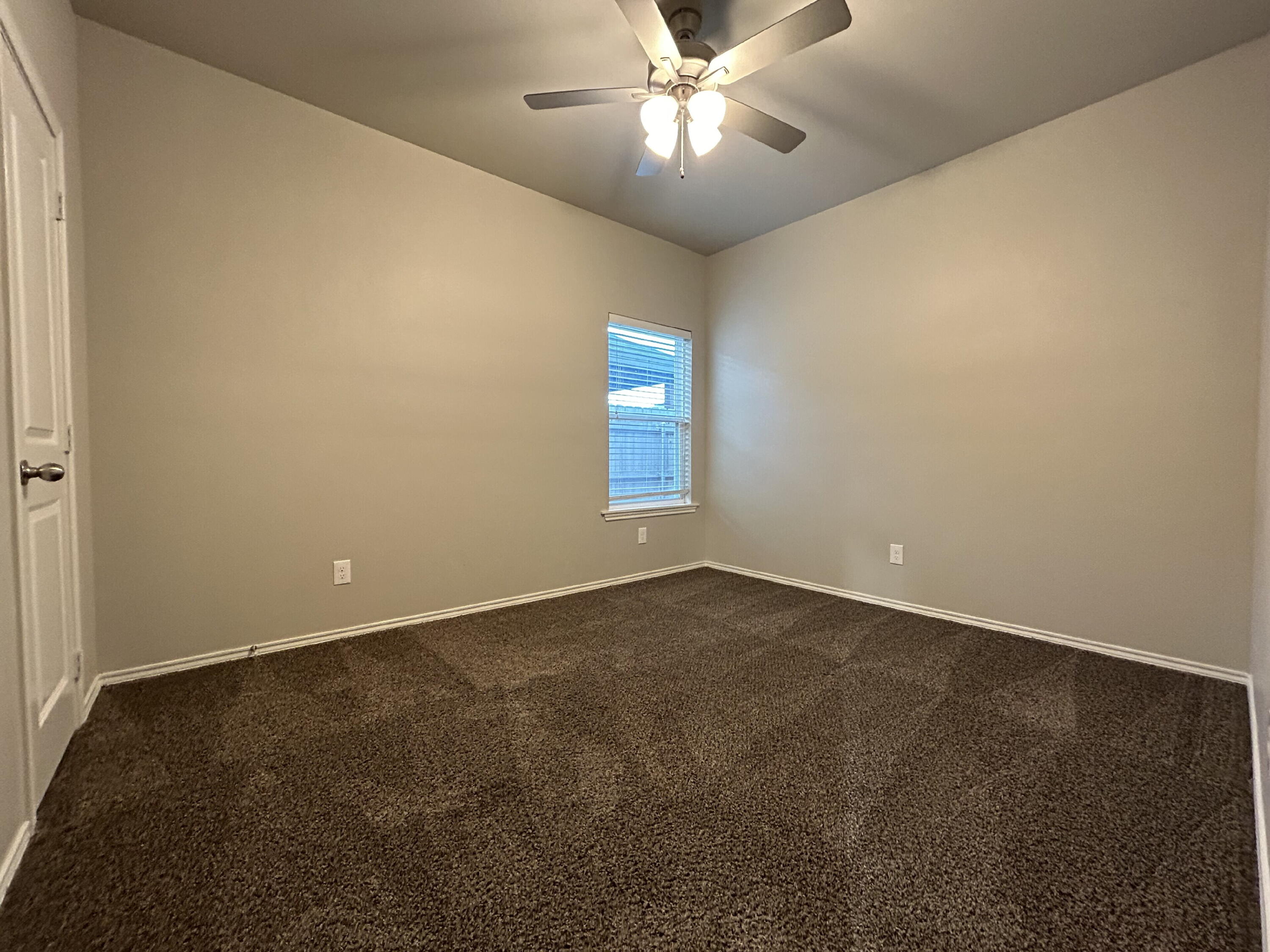 5843 Itasca Street Lubbock, TX 79416 - Photo 10 of 10 an empty room with a chandelier fan and windows