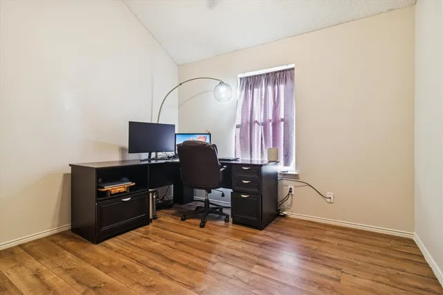 a view of a workspace with furniture and a window