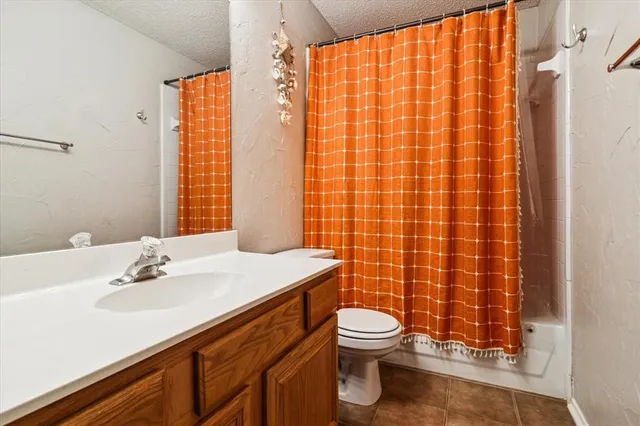 a bathroom with a sink a toilet and shower curtain