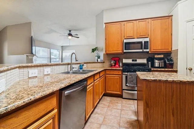 a kitchen with stainless steel appliances granite countertop a sink counter space cabinets and a window