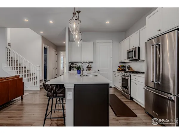 a kitchen with stainless steel appliances kitchen island a refrigerator sink and cabinets