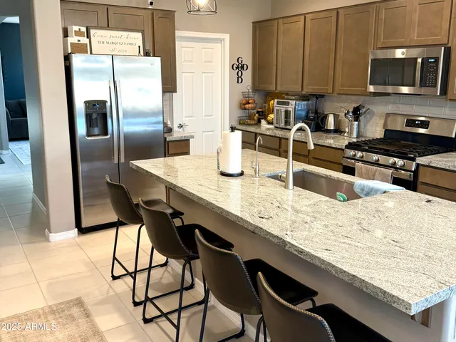 a kitchen with granite countertop stainless steel appliances and wooden cabinets