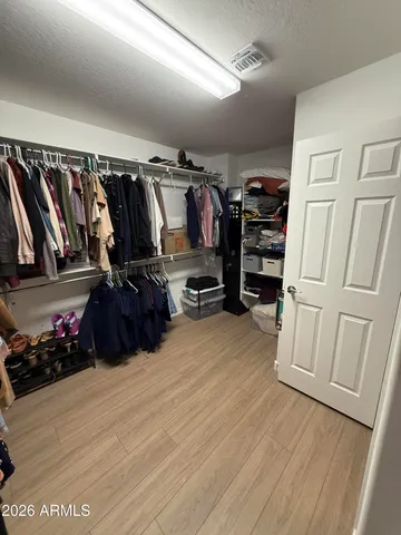 a view of walk in closet with clothes and shoes