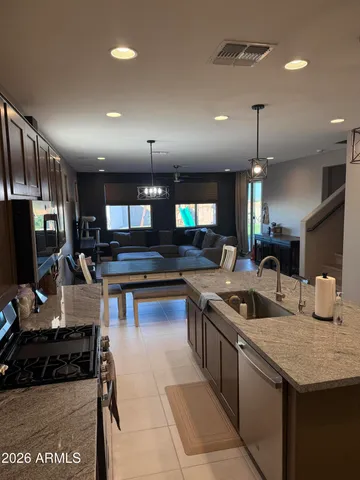 a kitchen with stainless steel appliances granite countertop a sink a stove and a refrigerator