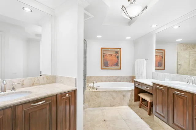a bathroom with a granite countertop tub sink and mirror