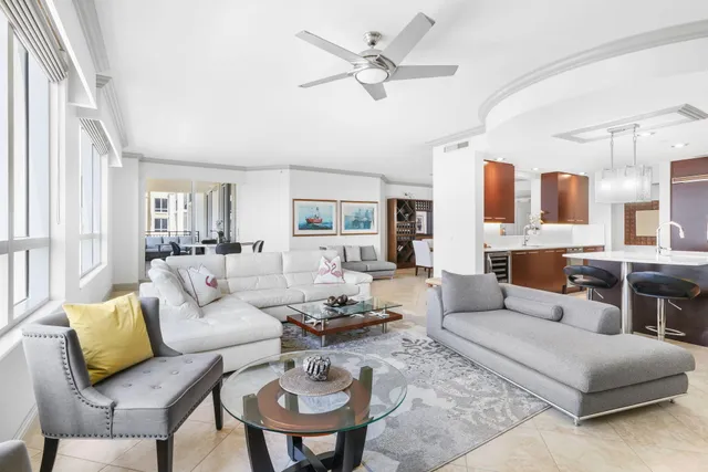 a living room with furniture kitchen view and a large window