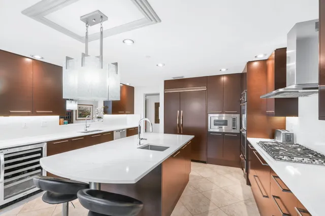 a kitchen with stainless steel appliances kitchen island a sink stove and refrigerator