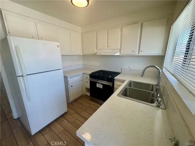a kitchen with a refrigerator sink and cabinets