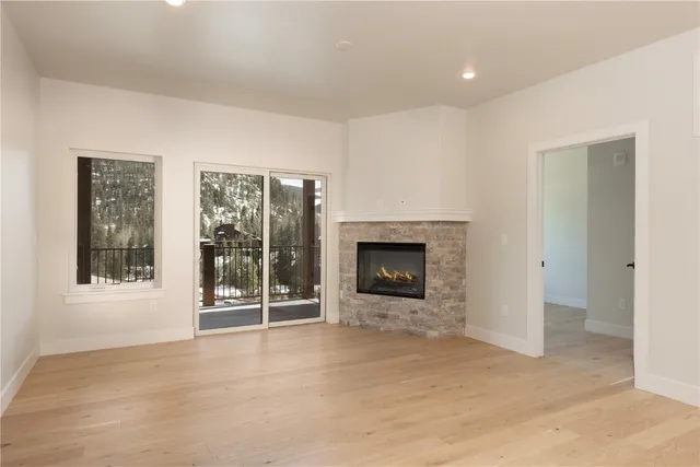 a view of an empty room with a fireplace and a window