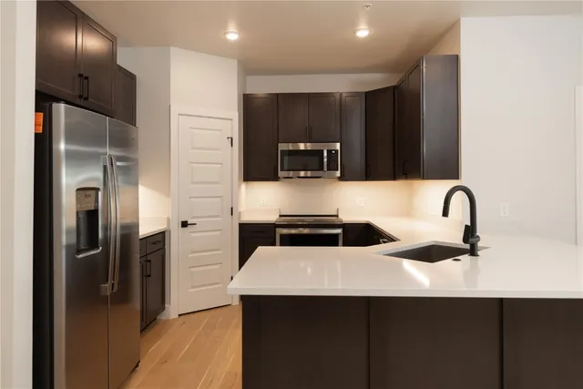 a kitchen with stainless steel appliances a sink and a refrigerator