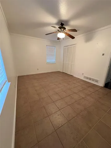 a view of an empty room with a chandelier fan
