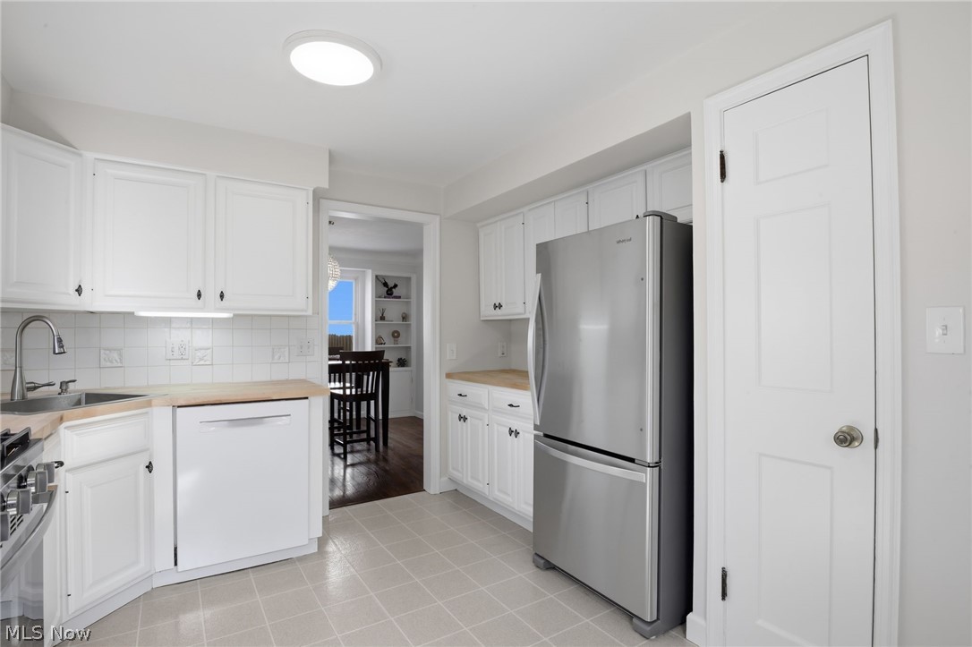 1390 Brainard Road Lyndhurst, OH 44124 - Photo 14 of 33 Kitchen featuring stainless steel appliances, white cabinets, tasteful backsplash, and light tile patterned floors