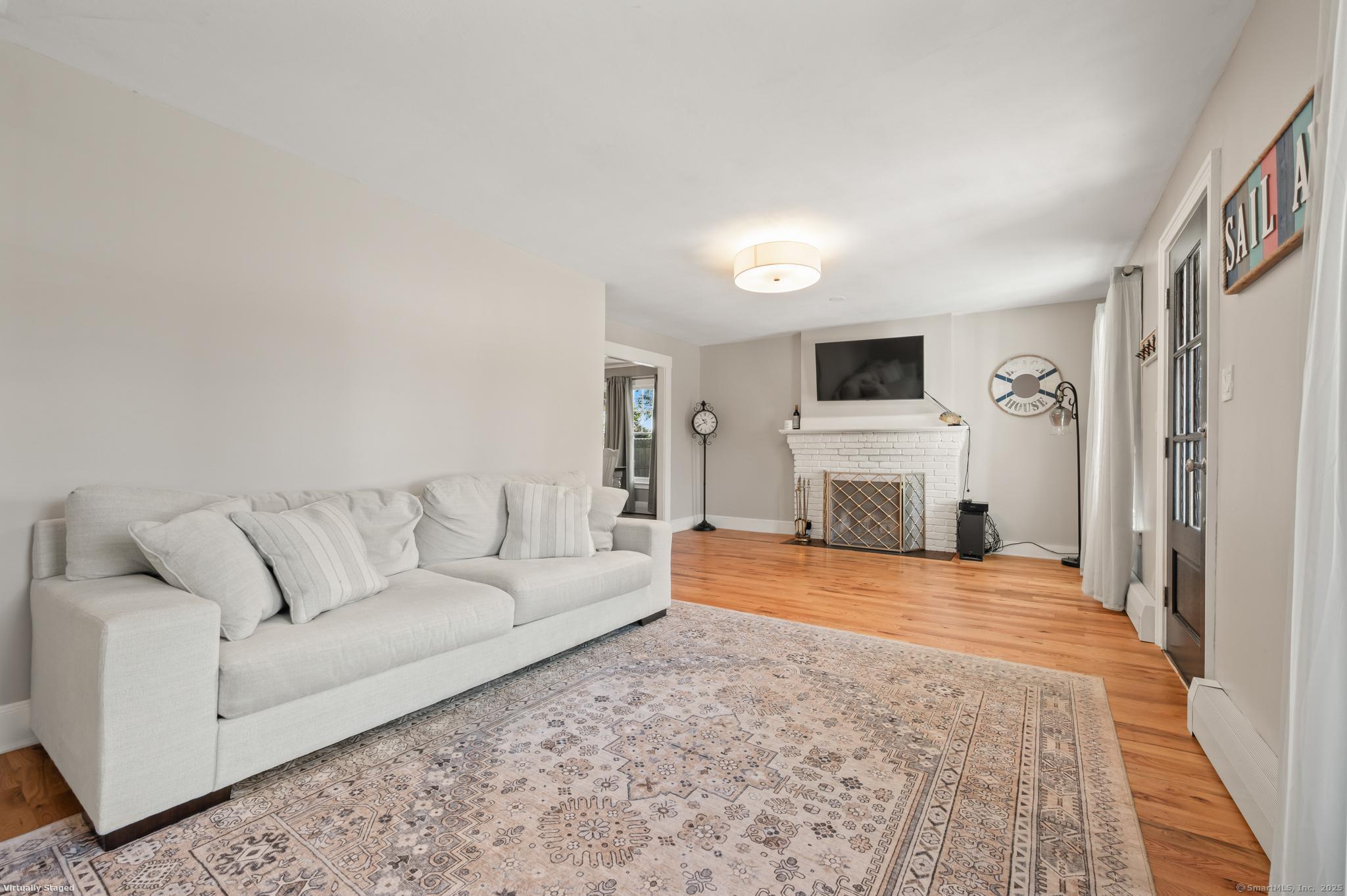 6 Howe Street Milford, CT 06460 - Photo 12 of 32 a living room with furniture a flat screen tv and a fireplace