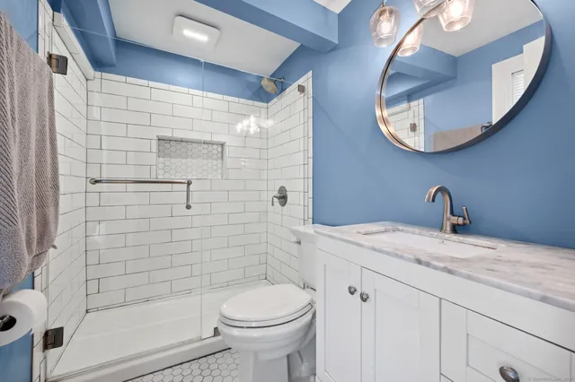 a bathroom with a sink a toilet and shower