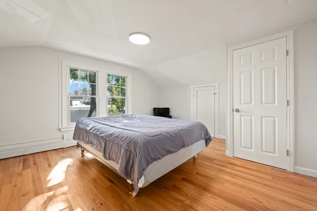 a bedroom with a bed and wooden floor